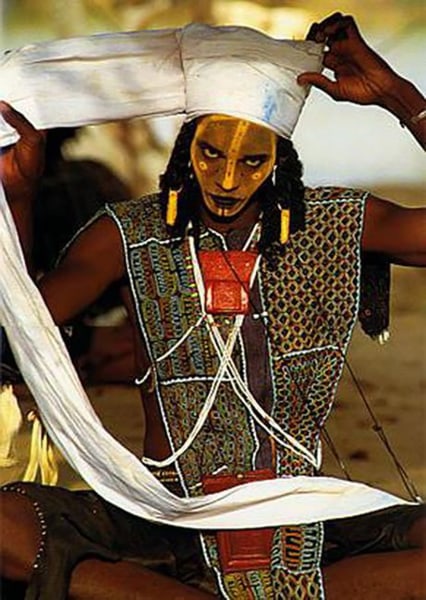 Carol Beckwith and Angela Fisher, Wodaabe man wraps a twelve-foot-long turban in preparation for the Yaake charm dance, Niger