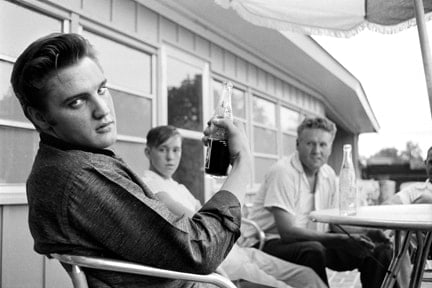 Alfred Wertheimer, Pepsi in Hand: Elvis Presley sitting on the porch of his home at 1034 Audobon Drive, Memphis, Tennessee, July 4, 1956