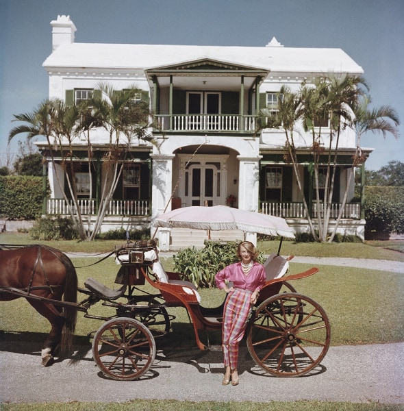 Slim Aarons, Bermudan Hostess: Polly Trott Hornburg in front of her father's house, 1957