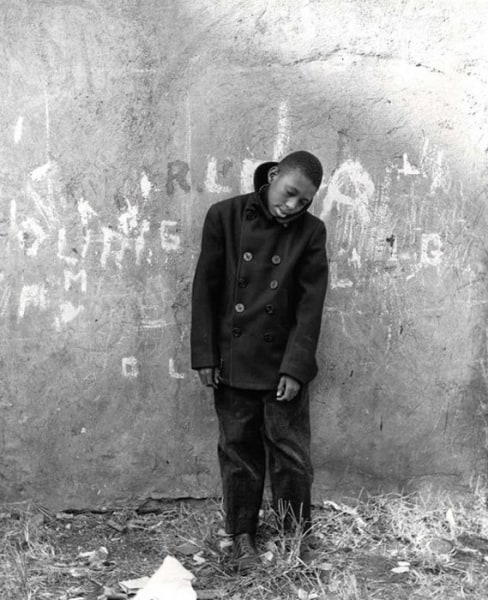 Young boy in front of wall by Vivian Cherry