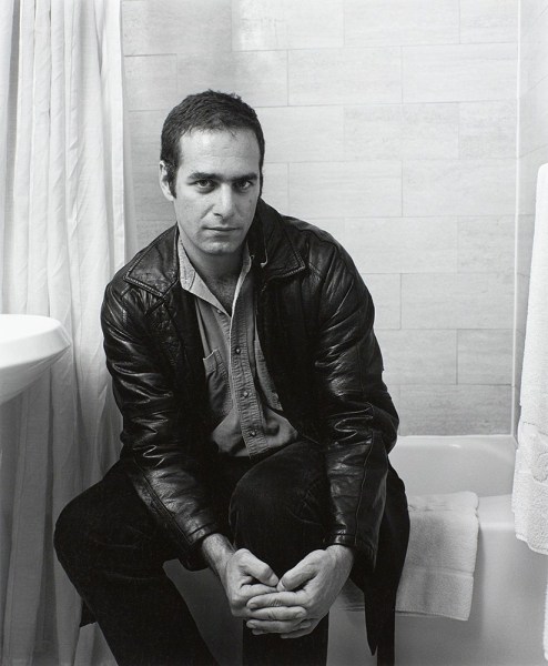 Man sitting on bathtub by Stephen Barker