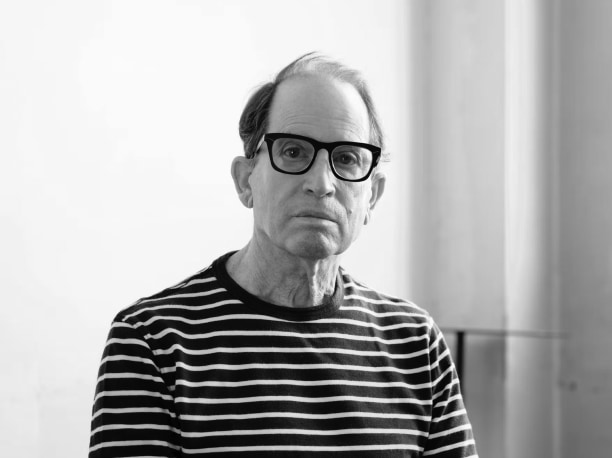 bust portrait of Peter Schlesinger wearing glasses and a striped shirt