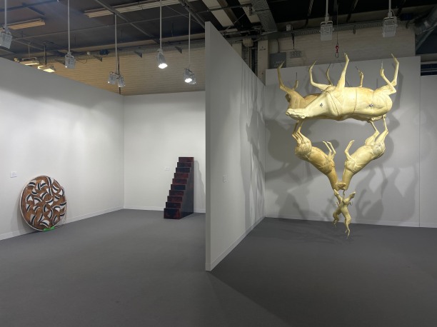 Installation view featuring three sculptures, two on the floor and one suspended from the ceiling.