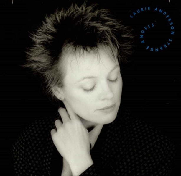 Cover of Laurie Anderson's Strange Angels, portrait of Laurie Anderson with hand against chin looking down with eyes closed.