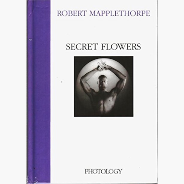 Portrait of ken moody with eyes closed, holding a lily; book cover has purple spine.