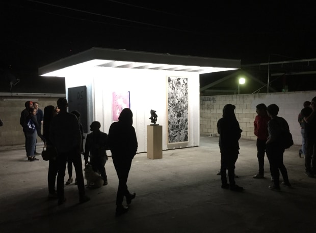 individuals standing in groups at night