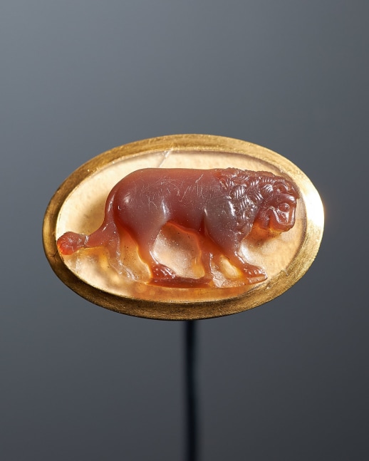A large cameo of a lion from the court of Frederick II, c. 1230
Southern Italy
Sardonyx cameo in a modern gold ring setting on a white paper backing; a small sardonyx repair to the upper left corner behind the animal&amp;rsquo;s haunches
5/8 x 7/8 inches
(1.7 x 2.3 cm)