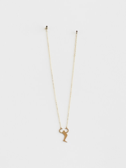 A gold plated necklace in the shape of the stone installation on the floor which resembles a leg emerging from a broken infinity symbol.