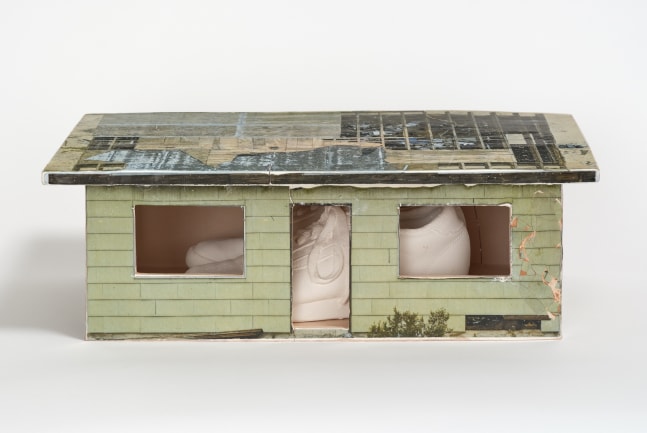 A ceramic shoe box sized replica of a house with decal photographic glaze and slip cast porcelain sneakers inside.