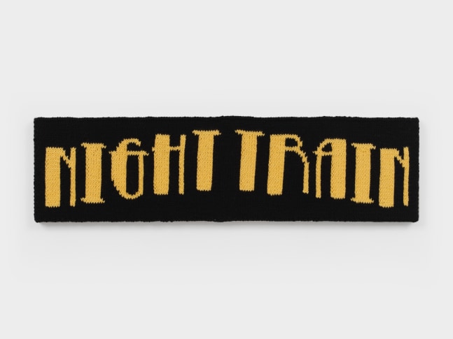 A knit artwork depicting the words &quot;Night Train&quot; in yellow yarn against a black background, sewn into linen and stretched.
