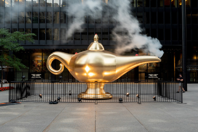A large inflatable sculpture of a golden smoking lamp installed outdoors.