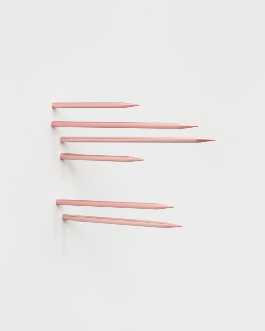 Six thin pink metal spikes emerging from the gallery wall.
