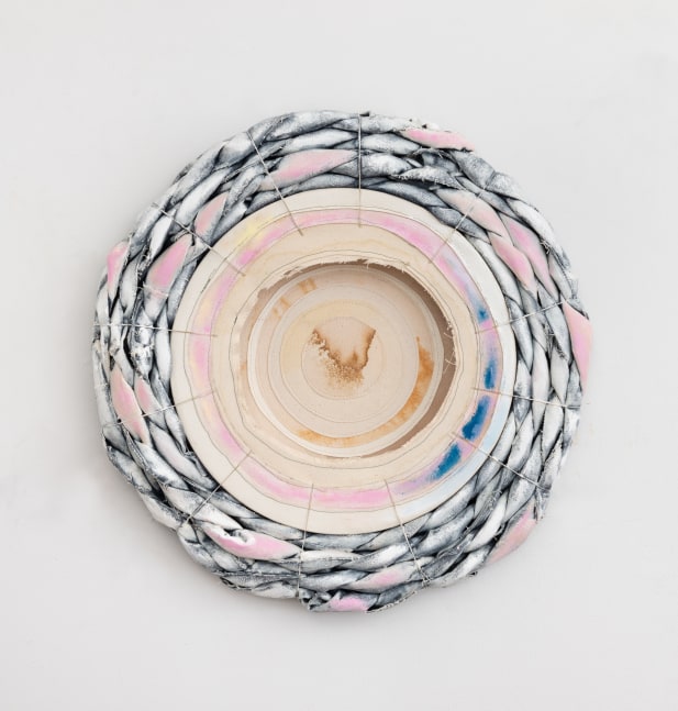 An inverted tondo with rings of sewn canvas surrounded by pink and white braids of painted denim around the periphery.