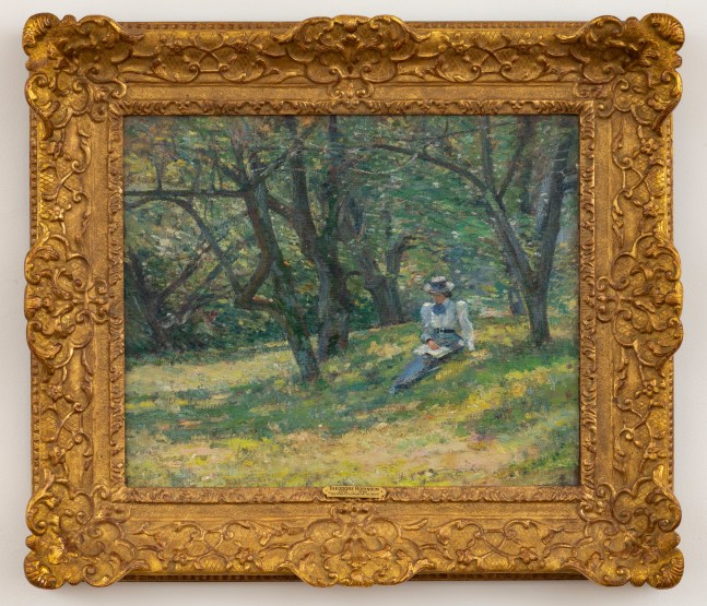 An impressionist painting by Theodore Robinson (1852–1896) that depicts a woman seated in an orchard reading a book . Oil on canvas, 18 x 22 in., signed lower right (framed)