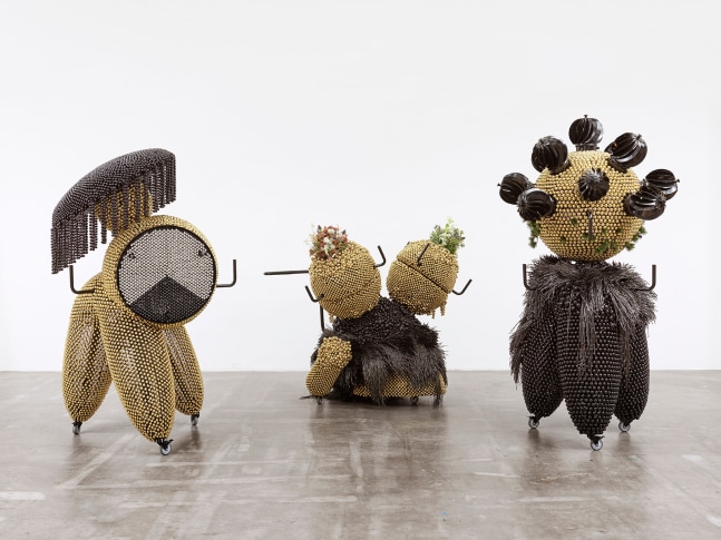 sonic intermediates &amp;ndash; triad walker trinity (sonic intermediate &amp;ndash; tripodal venting walker, sonic intermediate &amp;ndash; spinning mask on parasol walker, sonic intermediate &amp;ndash; botanical bi-headed creeping walker), 2020

set of 3 pieces. powder-coated steel frame, powder-coated mesh, powder-coated handles, casters, brass plated bells, black brass plated bells, metal rings, plastic twine, turbine vents, artificial plants, pine cones. powder-coated steel frame, powder-coated mesh, powder-coated handles, ball bearing, casters, nickel plated bells, brass plated bells, black brass plated bells, metal rings. powder-coated steel frame, powder-coated mesh, powder-coated handles, ball bearings, casters, brass plated bells, black brass plated bells, metal rings, plastic twine, artificial plants, multilayer foam

83.46 x 47.64 x 47.24 in

75.98 x 47.24 x 43.7 in

59.06 x 53.15 x 71.65 in