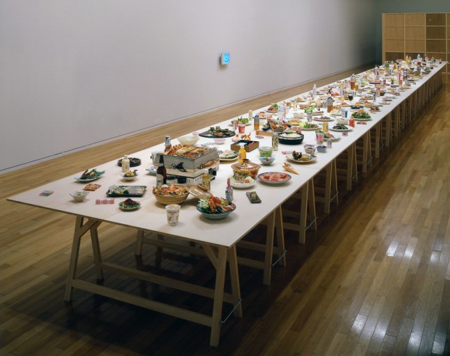 untitled 2002 (the raw and the cooked), 2002
long table, custom-made plastic foods, drinks, monitors screening footage of people making fake food

variable dimensions