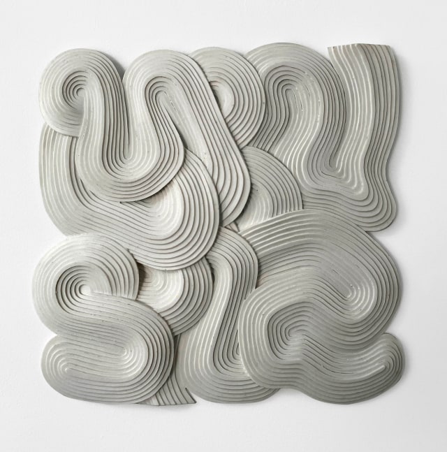 bonded marble bas-relief of a curving and overlapping ribbon-like forms
