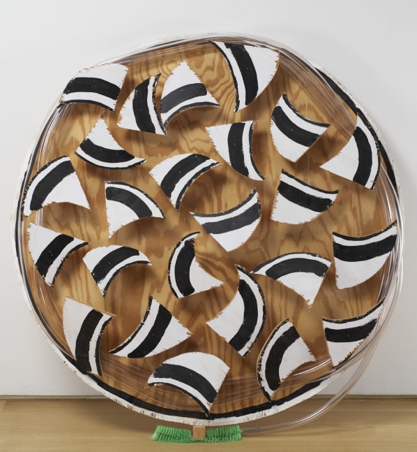 Round wall-mounted artwork with a wood panel background featuring multiple black-and-white painted fragments arranged in a circular composition.