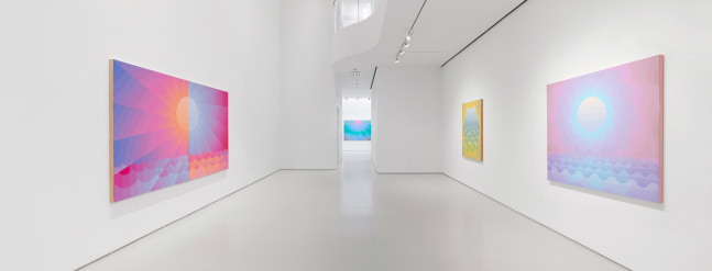 white walled gallery with large pink, orange, and blue diptych painting of a sun on the left wall and two paintings on the right wall, one pink, blue, and purple and the other yellow, blue, and green. On the back wall of the gallery, a painting of a sun in blue, pink, and green.