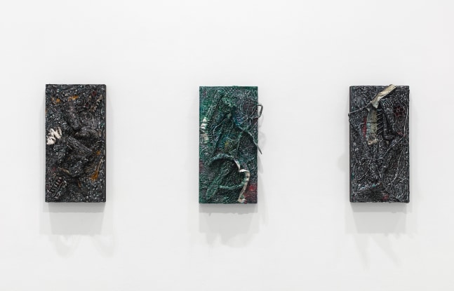 Three small, dark and textured artworks of the same size hang on white gallery wall.