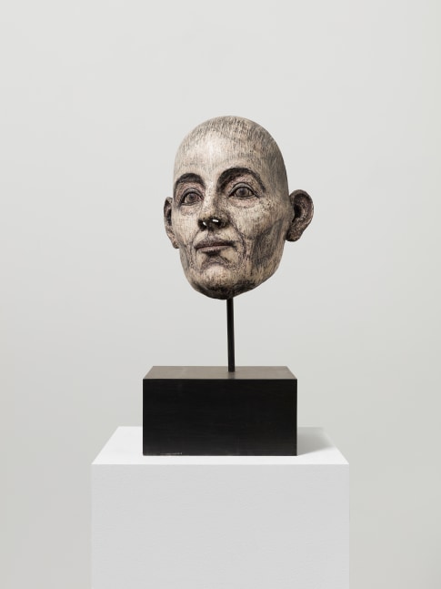 Resin, fiberglass, stone dust and acrylic sculpture of a head with dark features