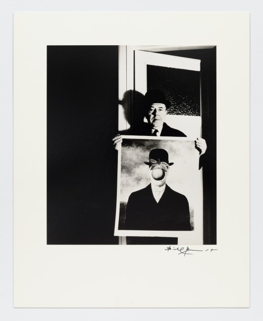 Black and white photographic portrait of man holding Magritte's &quot;The Son of Man&quot; by Bill Brandt.