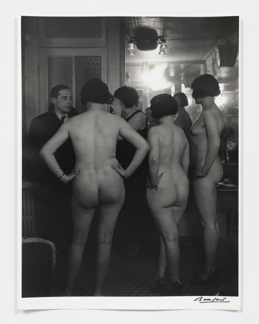 Black and white photographic portrait of three nude women standing before a man at Suzy's.