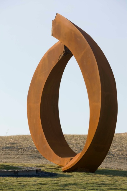 Photo of an oval-shaped sculpture installed in grass by Beverly Pepper