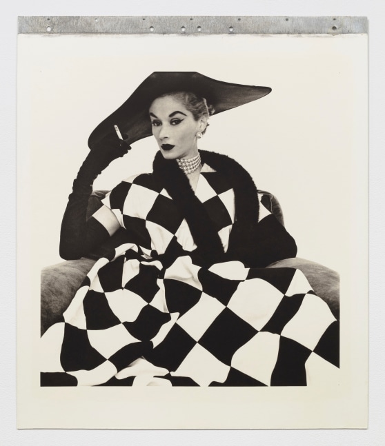 Black and white photographic portrait of a woman in checkered clothing.