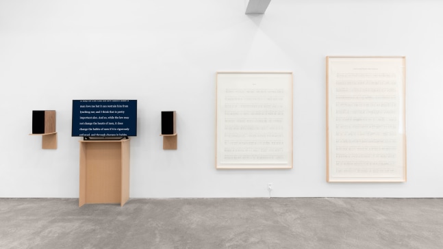 Charles Gaines Manifestos 3, 2018 video (black and white and color, sound), two graphite drawings on paper, one monitor, one pedestal, two speakers, hanging speaker shelves overall dimensions variable