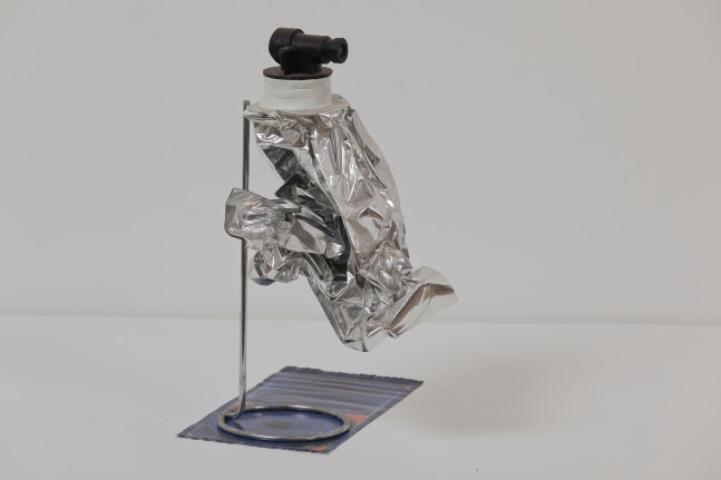 Untitled silver lining, 2009, found Polyethylene lining, camera lens, stainless steel stand, 24 x 19 x 9 cm / 9.5 x 7.5 x 3.5 in