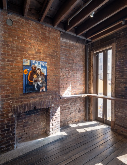 Image of front lobby with one small painting hung on exposed brick