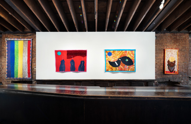 An image of four small quilts in the gallery lobby