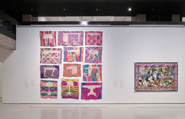Installation view at Barbican Art Gallery of two textile art works on a white wall