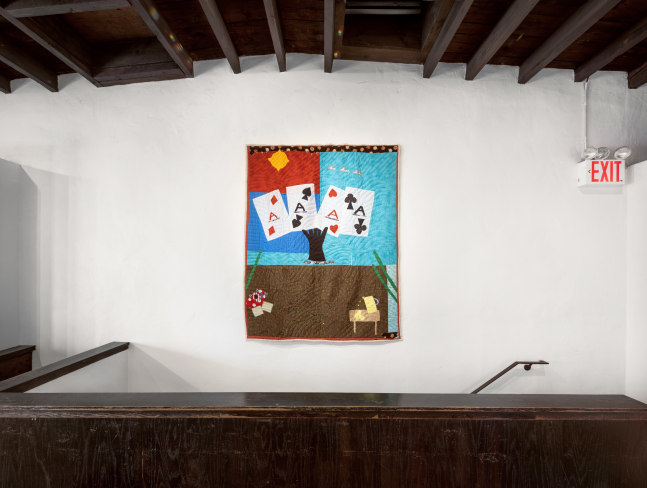 An image of a singular quilt on the third floor over the staircase