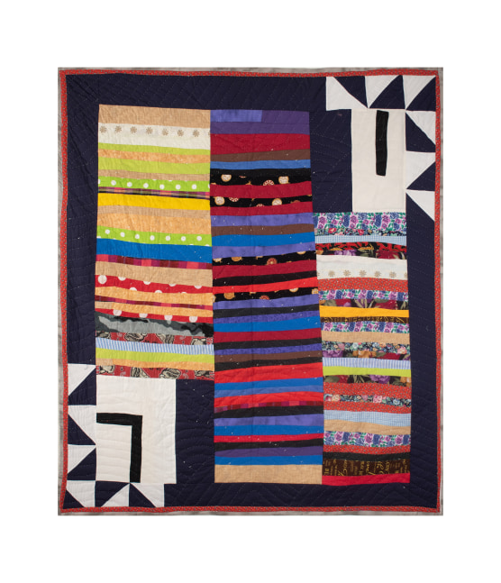 A darker hued assorted fabric quilt with colorful patterns and geometric shapes