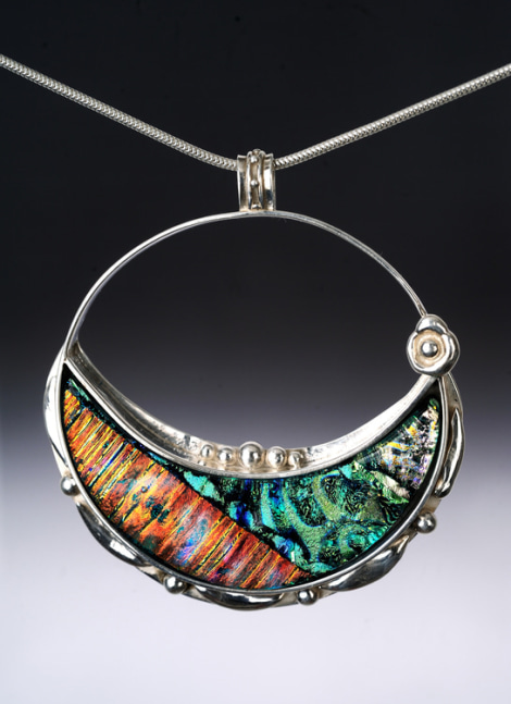 Luna del Mar
Layered dichroic glass set in heavy Argentium sterling silver bezel with silver embellishments.
2.25&amp;quot; x 2.5&amp;quot; x .5&amp;quot;
2019