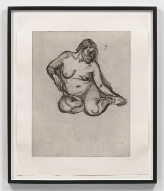 A Lucian Freud etching of a naked woman holding her foot in black ink on satin white paper