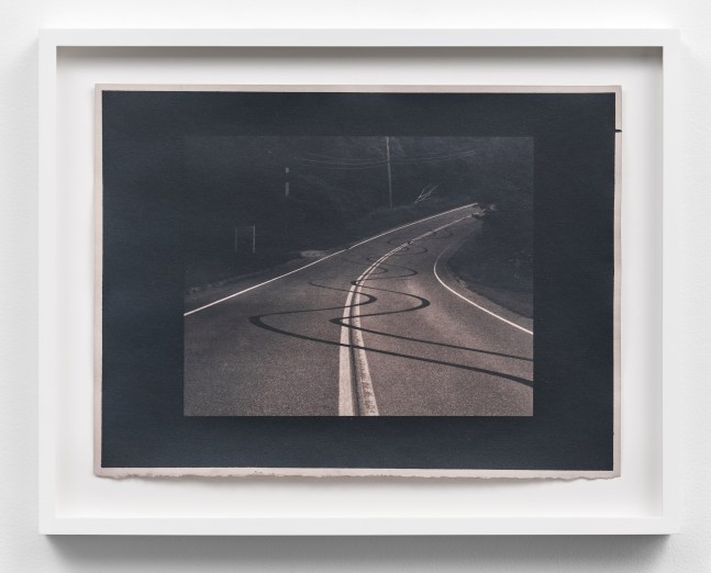 Scan of a rose toned cyanotype depicting burnout marks on a curved, two lane road by Mickey Aloisio