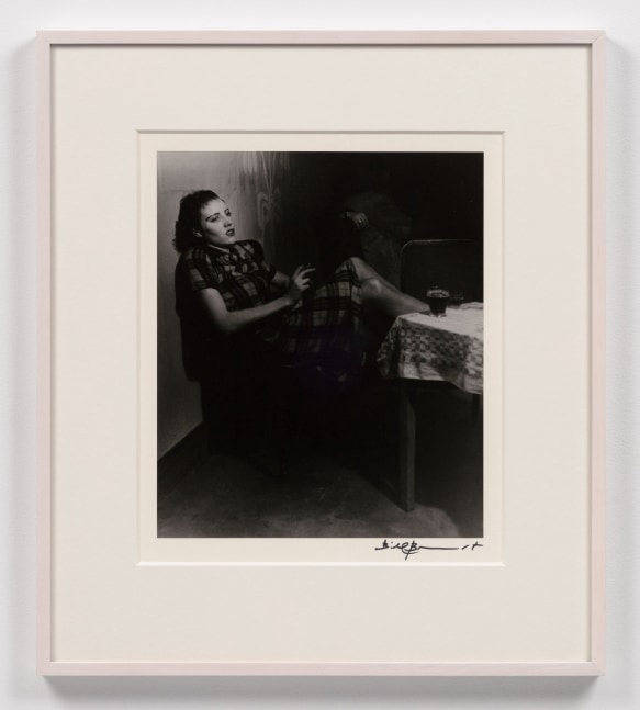 A black and white photographic print by Bill Brandt depicting a woman leaning back in a chair