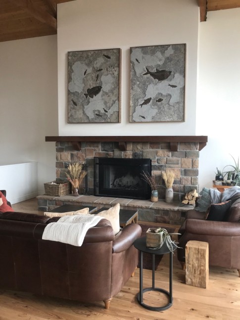 A fossil fish duptich that was quarried from a dark limestone layer hangs above a stone fireplace