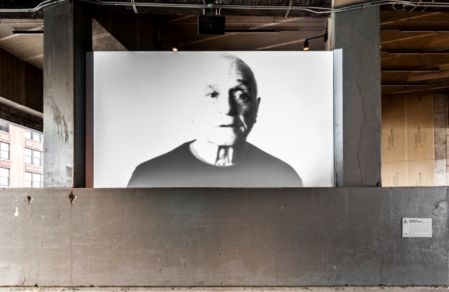 Installation view of video work by John Giorno