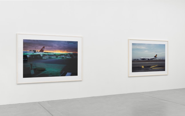 installation view of photographs of airports and car sculptures by Peter Fischli and David Weiss