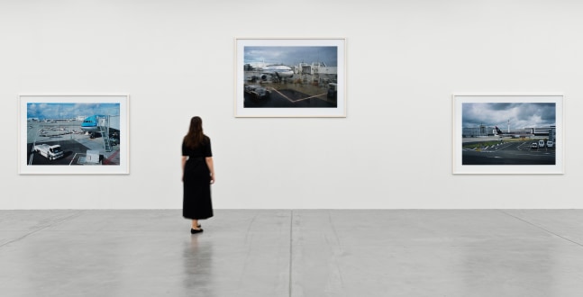 installation view of photographs of airports and car sculptures by Peter Fischli and David Weiss