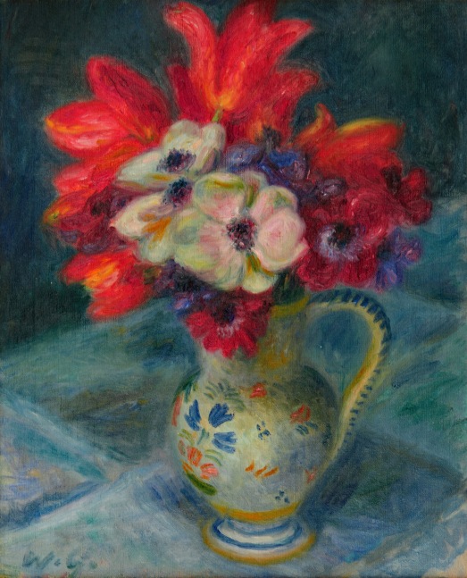 bouquet of red anemones and tulips in a french pottery pitcher on a table