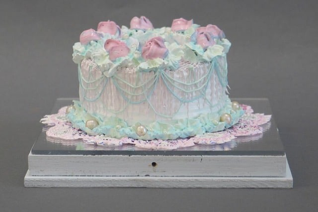 a fancy cake made from acrylic and wood in a plexiglass box