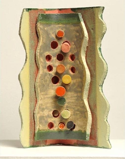 abstract construction of glazed ceramic with wave edges and small round discs and holes