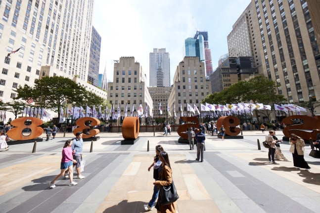 Installation view of&amp;nbsp;ONE Through ZERO (The Ten Numbers) (1980&amp;ndash;2003), Cor-Ten steel, and flags featuring images from the Peace Paintings series (2003), Rockefeller Center, New York, 2023. Photo: Tom Powel Imaging; Artwork: &amp;copy; The Robert Indiana Legacy Initiative/Artists Rights Society (ARS), NY