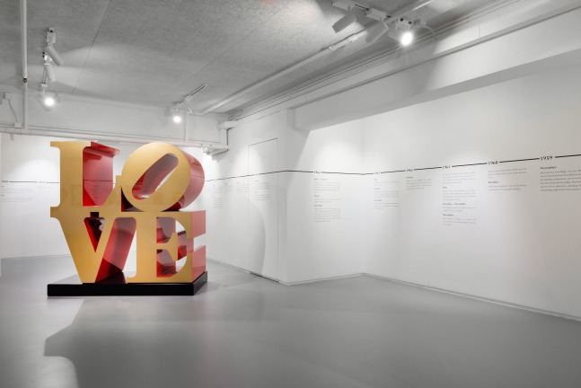 An installation view of a 72 inch LOVE sculpture with gold faces and red sides in the exhibition Robert Indiana at Ben Brown Fine Arts, Hong Kong, December 7, 2021–March 8, 2022