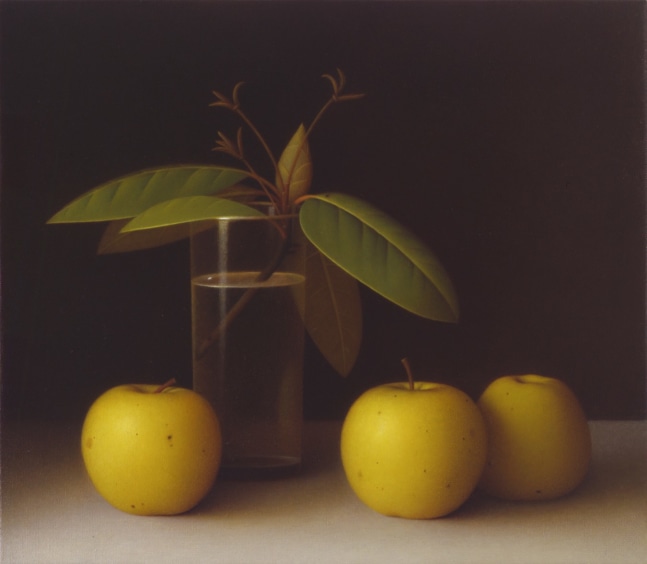 Still life painting of three yellow apples sitting on a grey table, with a cutting from a tree sitting in a glass of water behind them